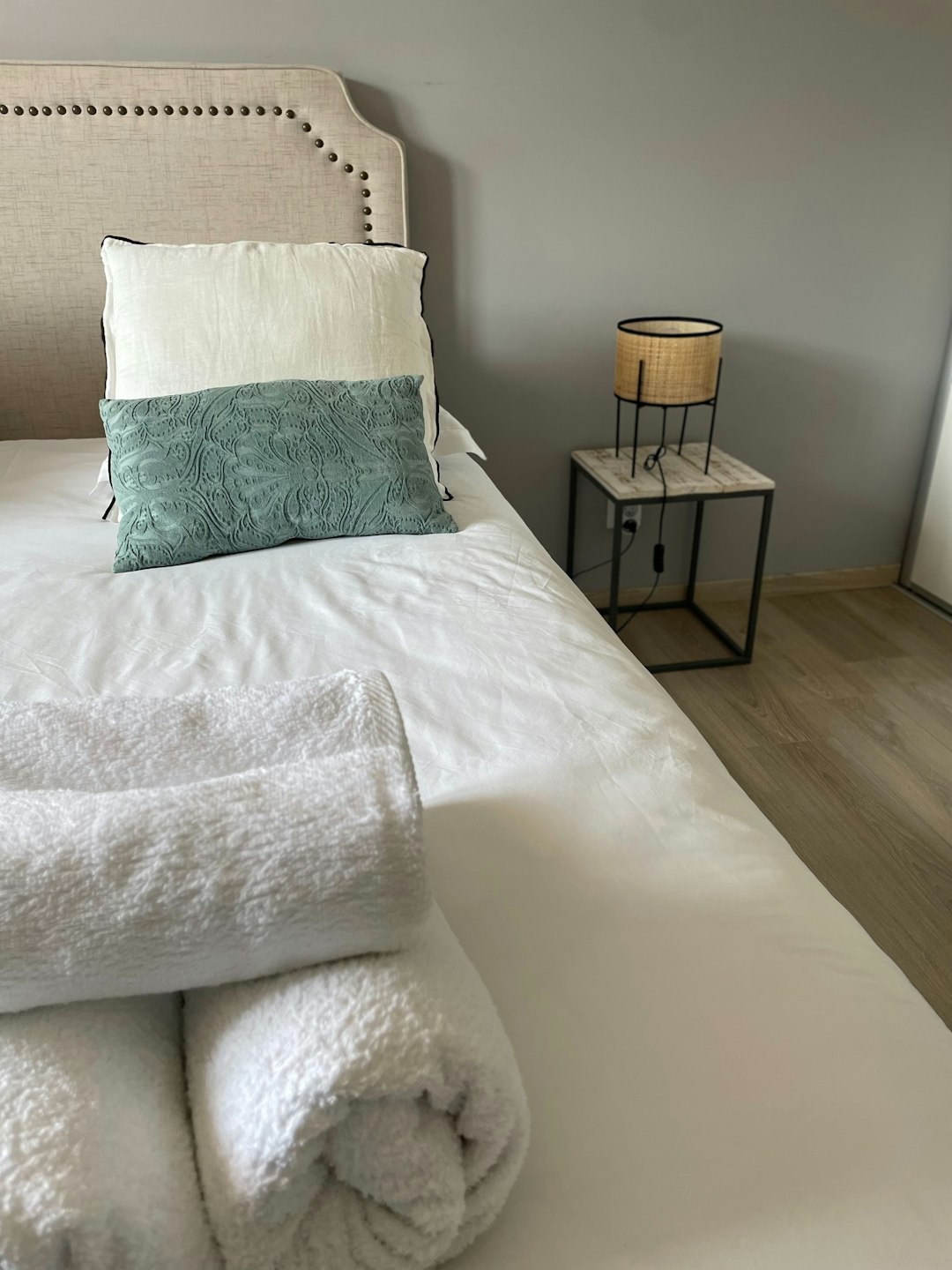 a-bed-with-a-white-blanket-and-pillows-nu6qc7zne98